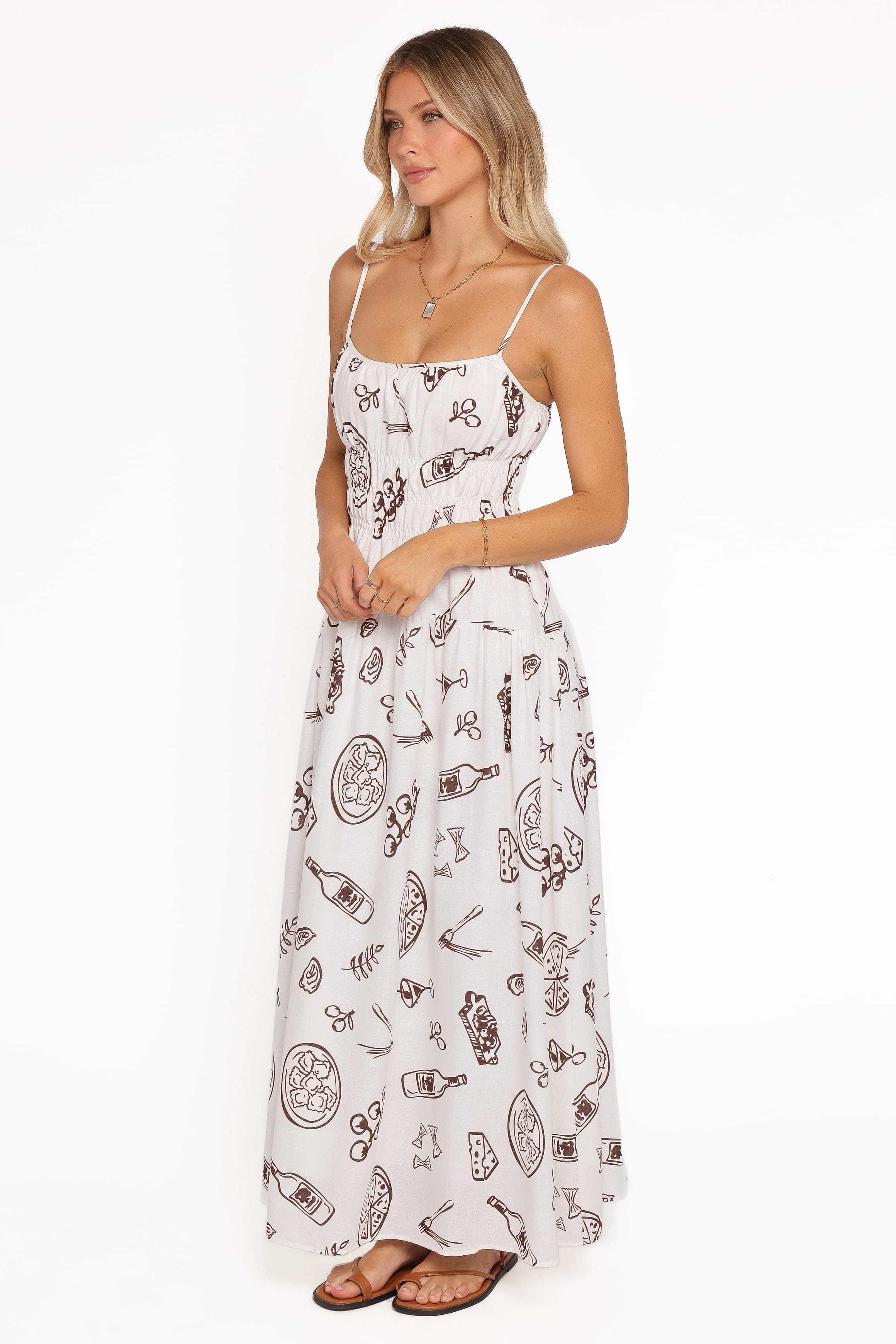 Woman wearing a white dress with brown patterns on a white background