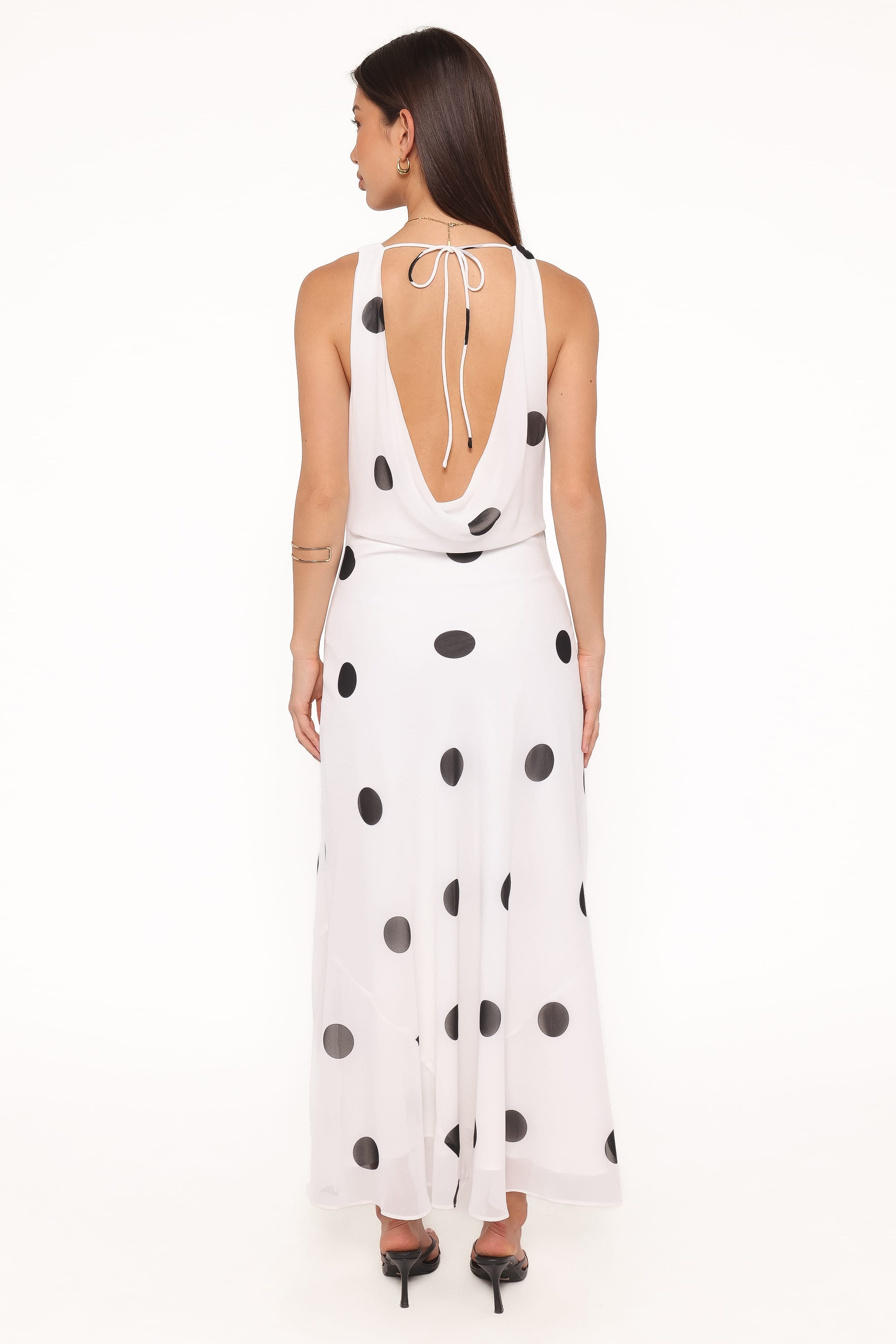 Woman wearing a white dress with black polka dots on a white background
