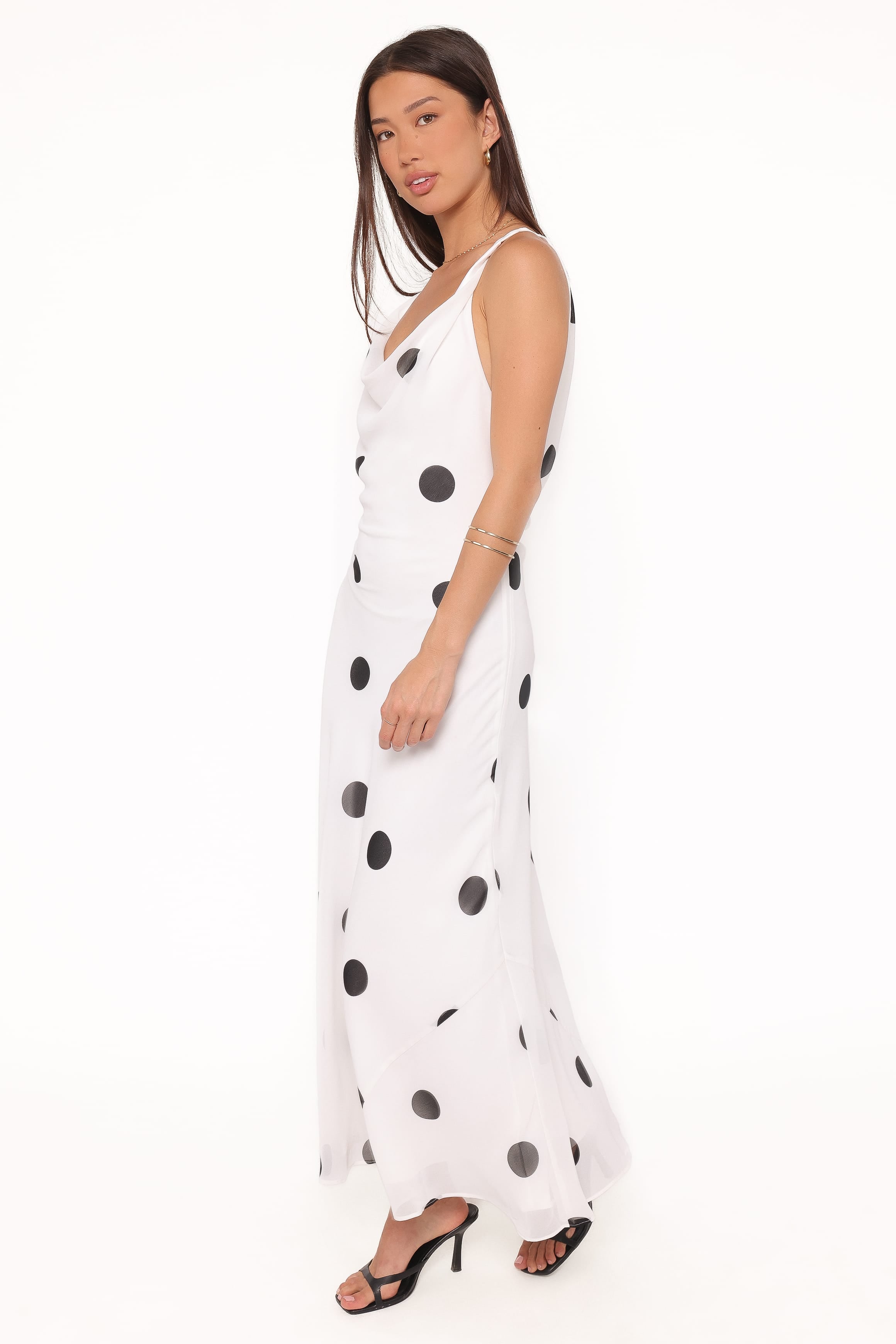 Woman wearing a white dress with black polka dots on a white background
