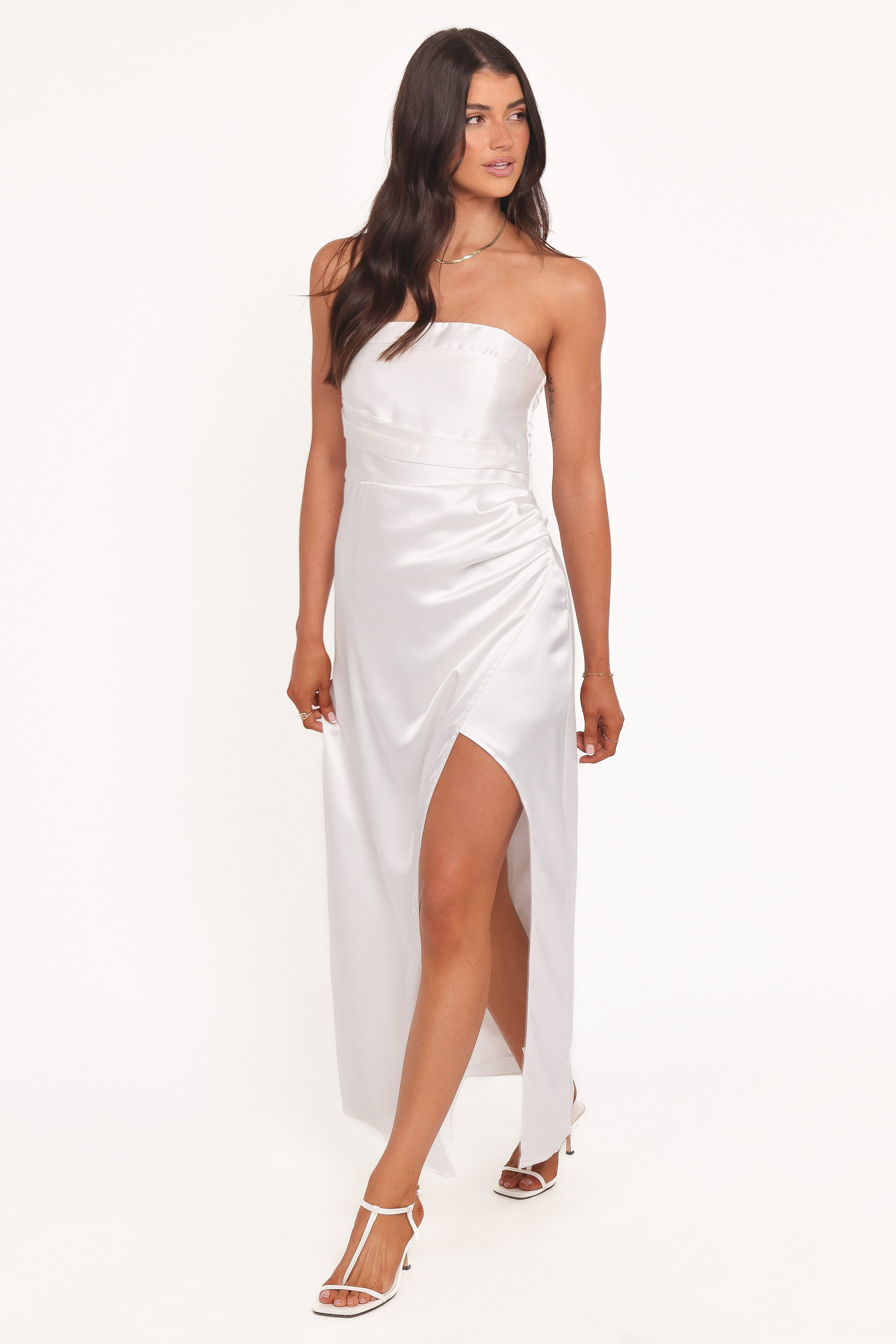 Woman wearing a white strapless dress on a white background