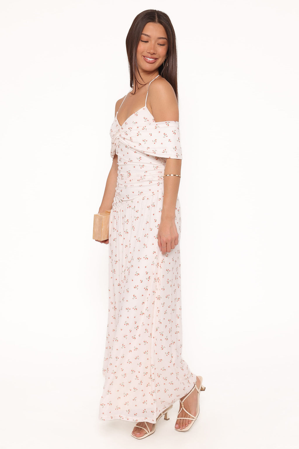 Woman wearing a floral off-shoulder dress on a white background