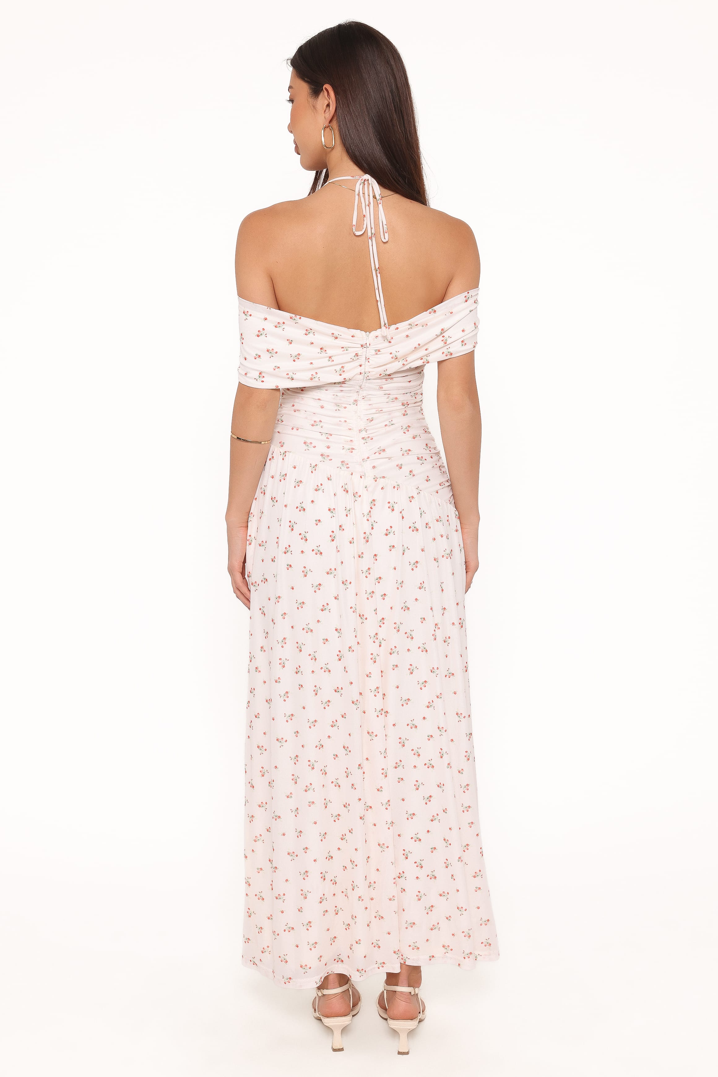 Woman wearing a white floral off-shoulder dress on a white background