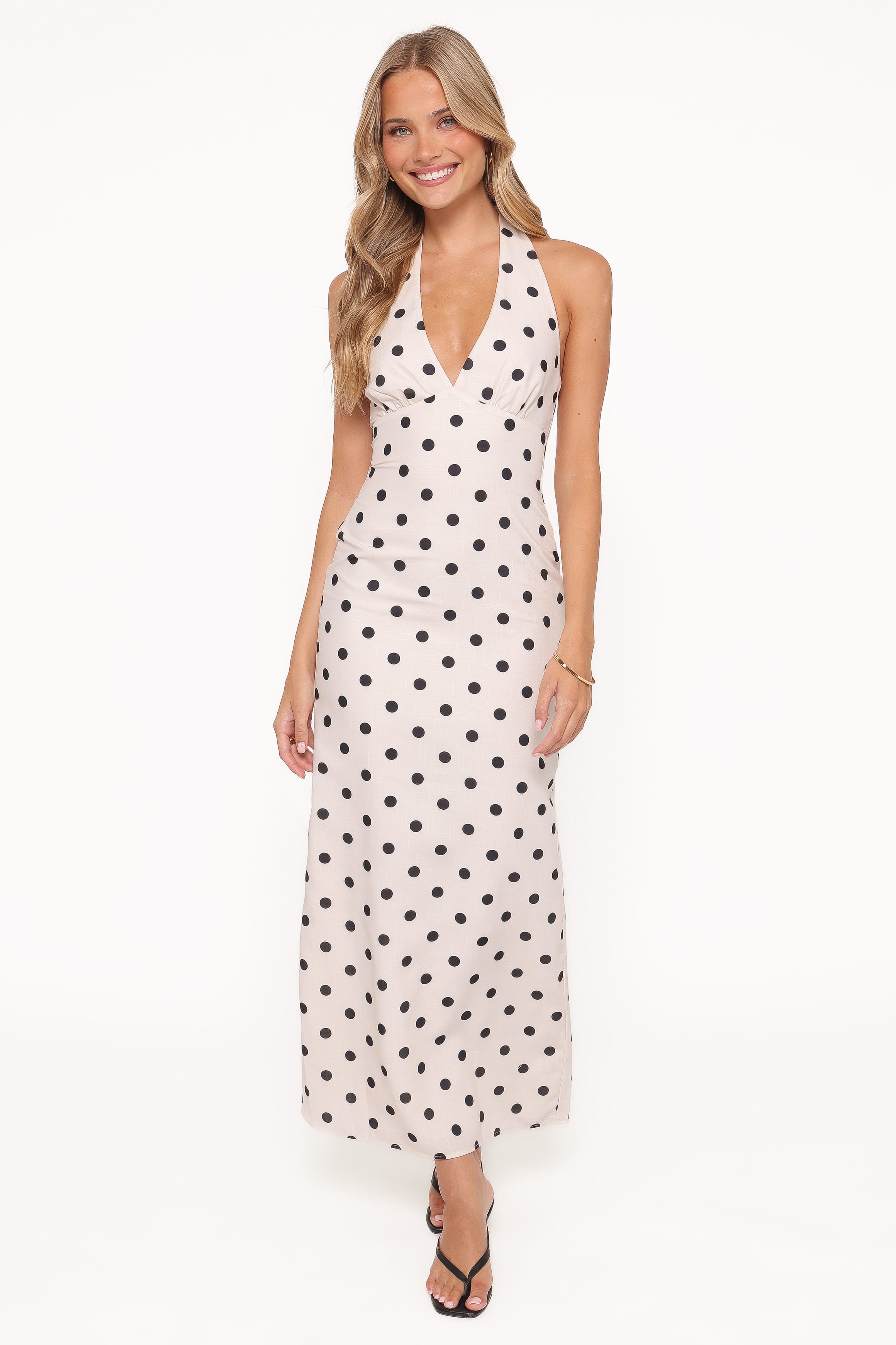 Woman wearing a white dress with black polka dots on a white background