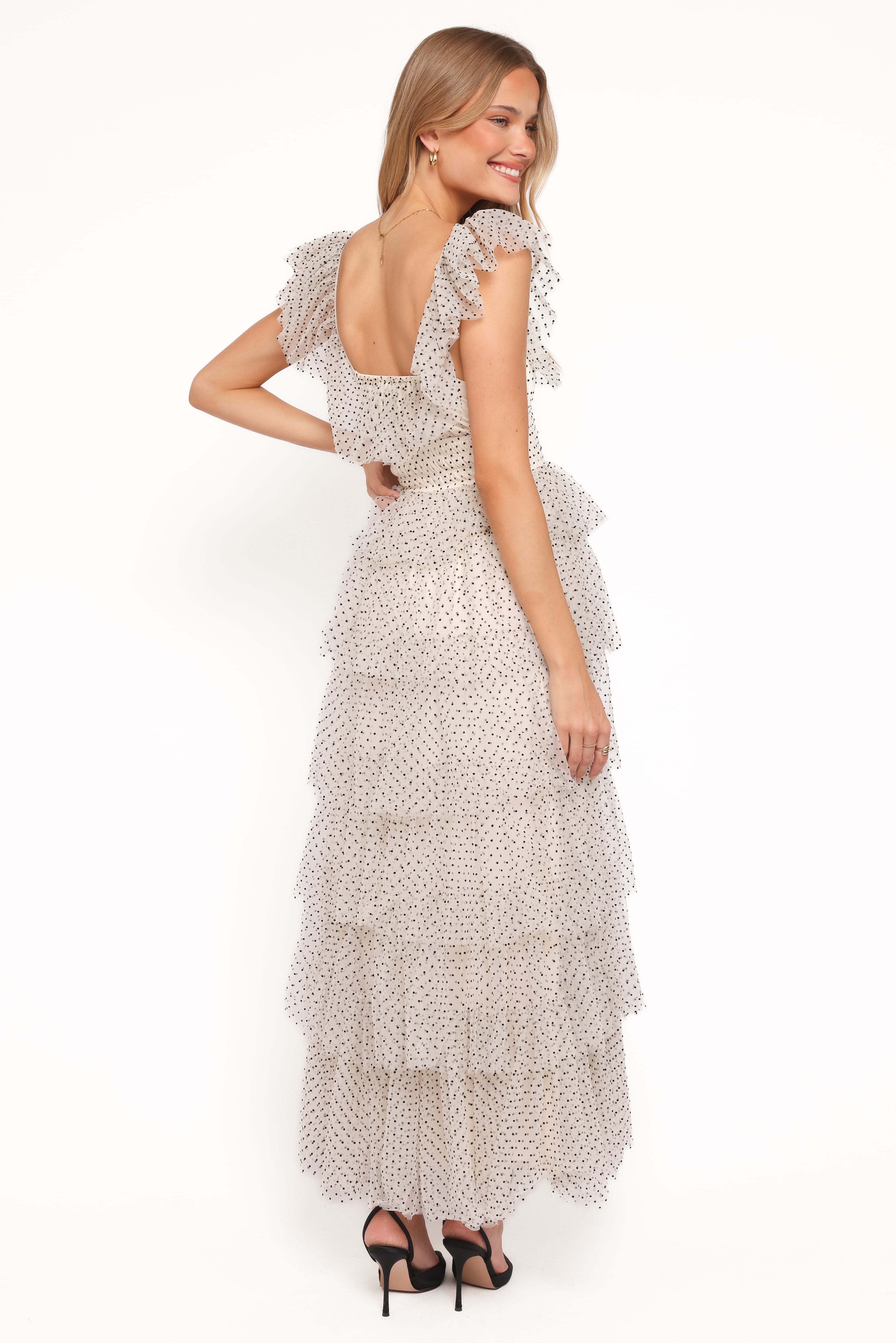 Woman wearing a long, patterned dress on a white background