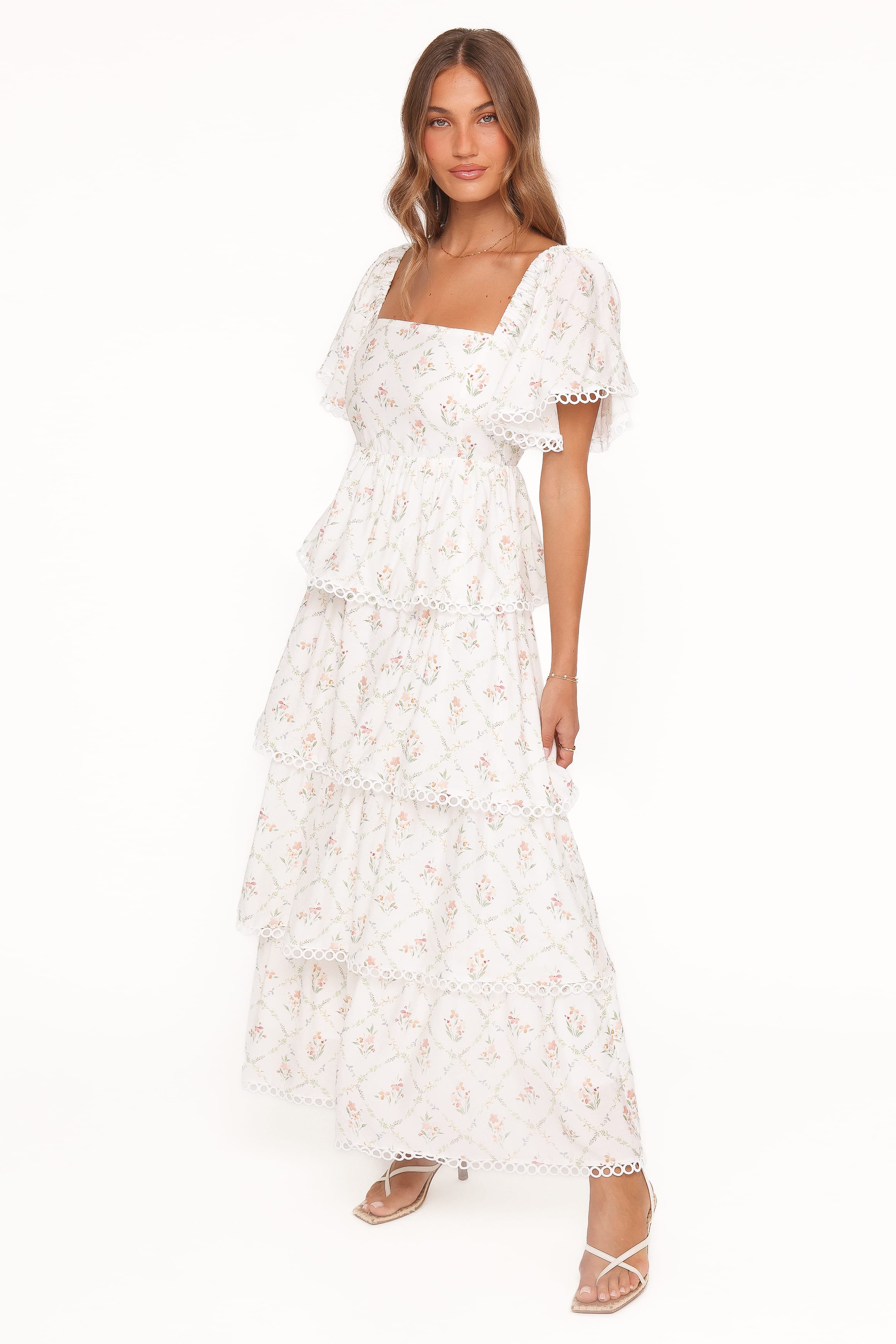 Woman wearing a white floral dress on a white background