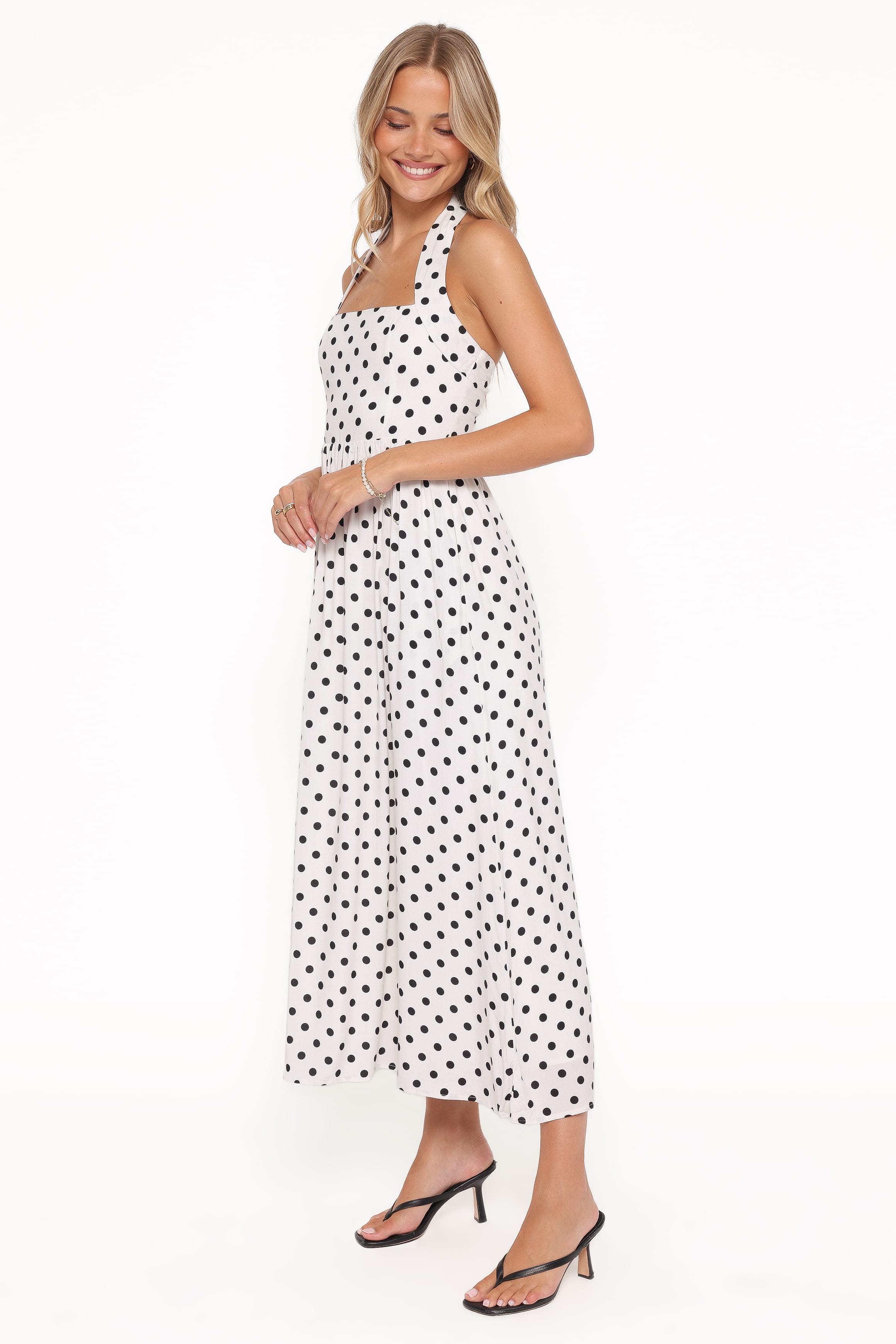 Woman wearing a white dress with black polka dots on a white background