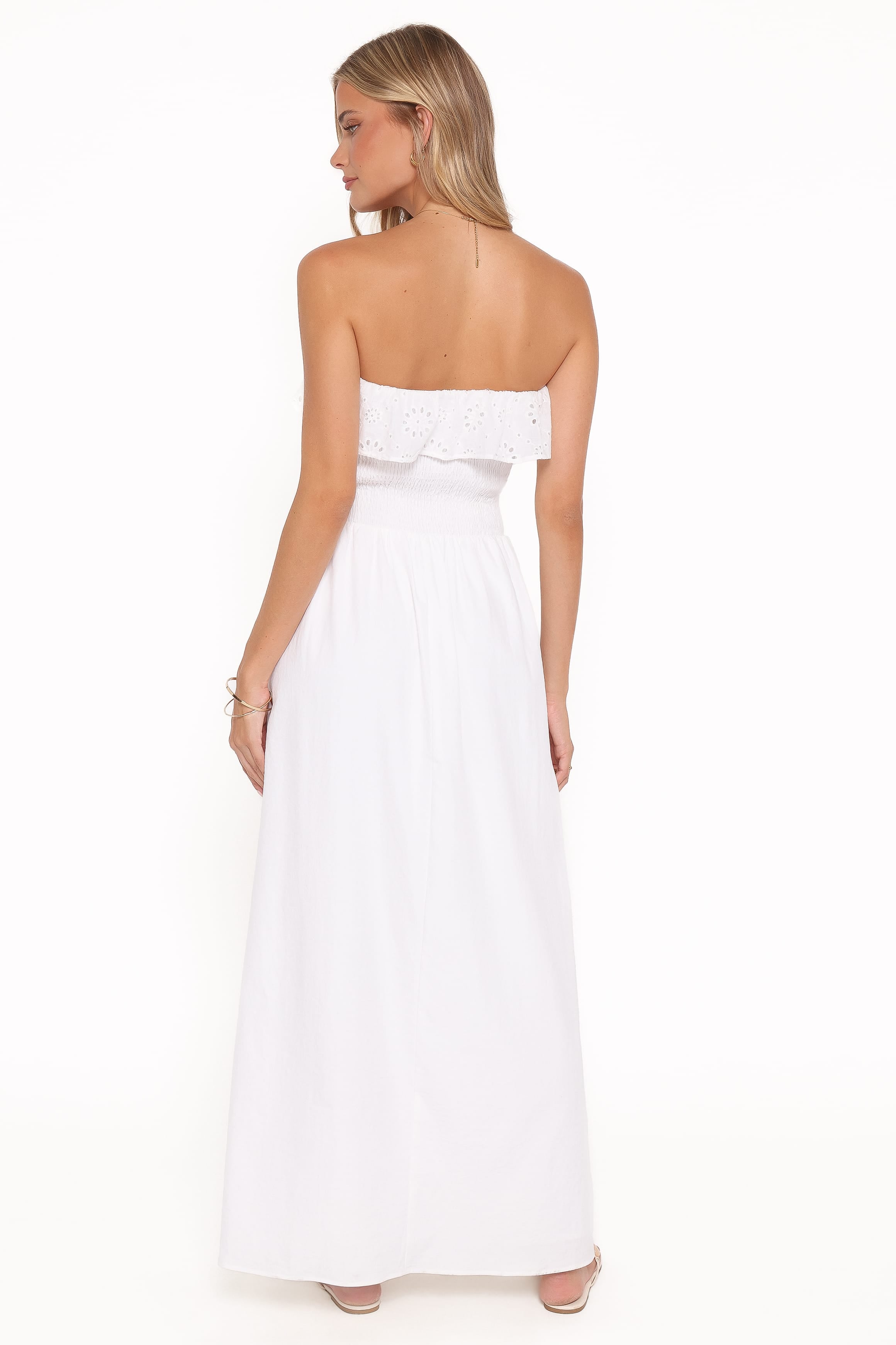 Woman wearing a strapless white dress on a white background