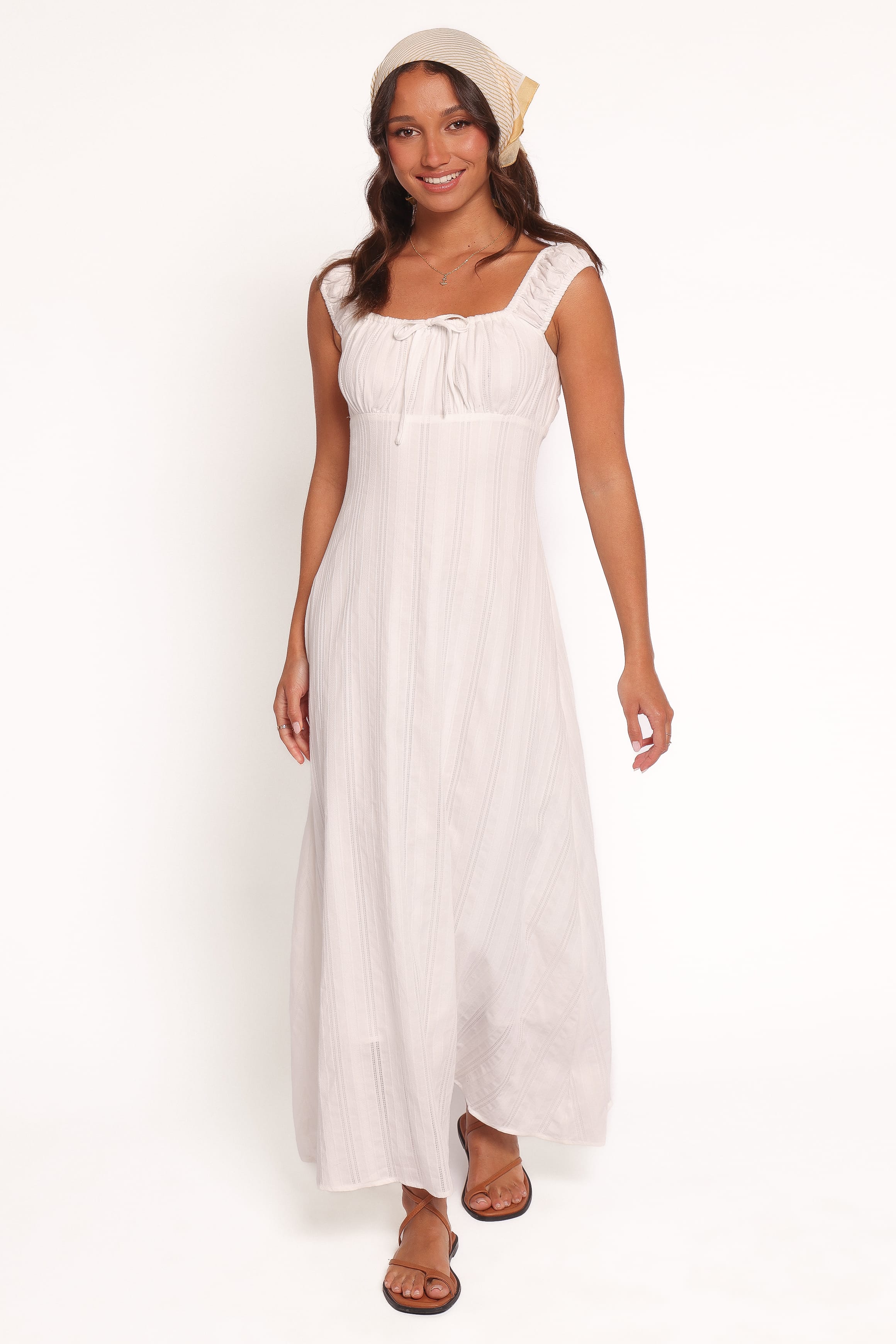 Woman wearing a white sleeveless dress on a white background