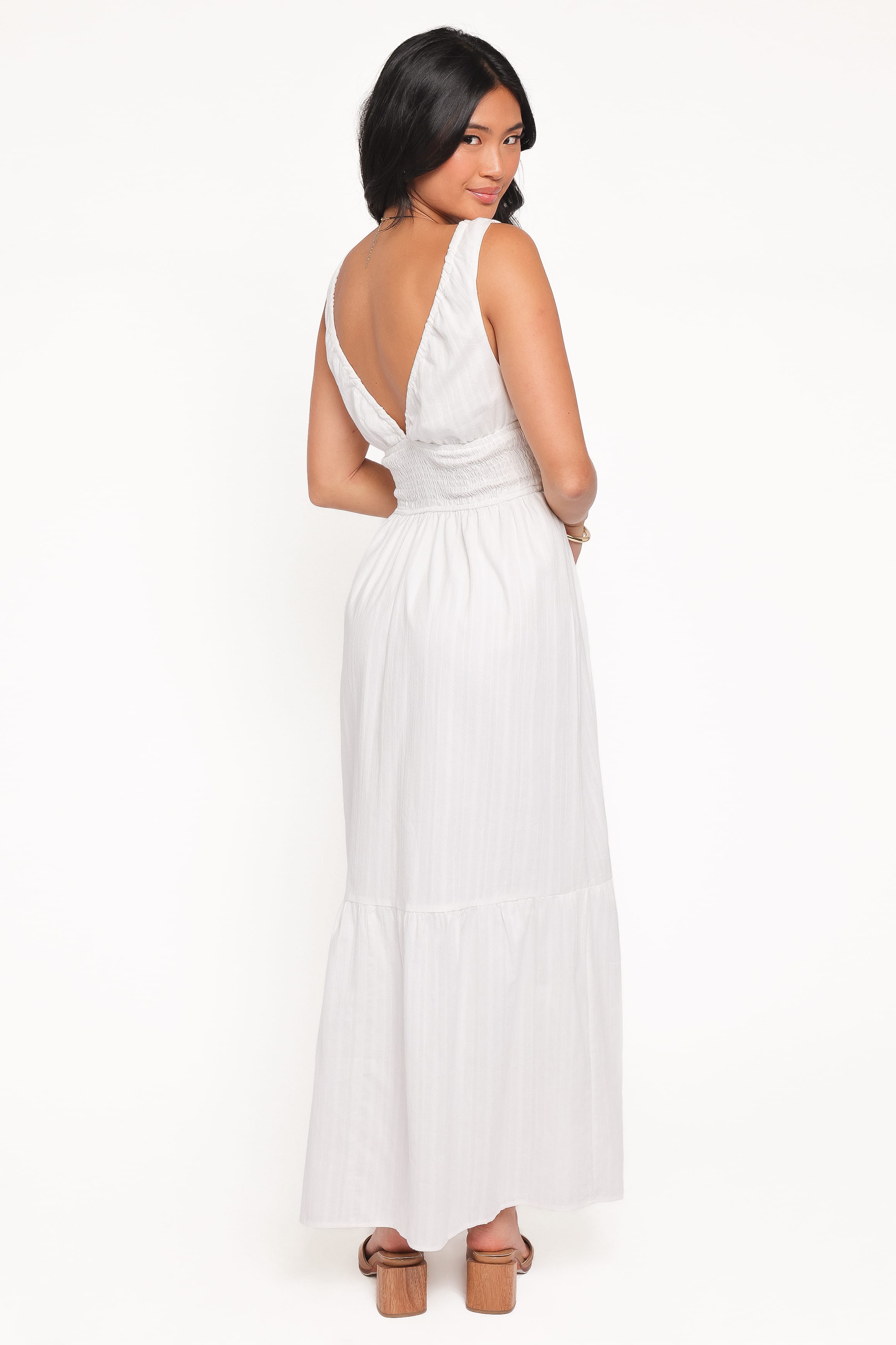 Woman wearing a white dress with a deep neckline on a white background