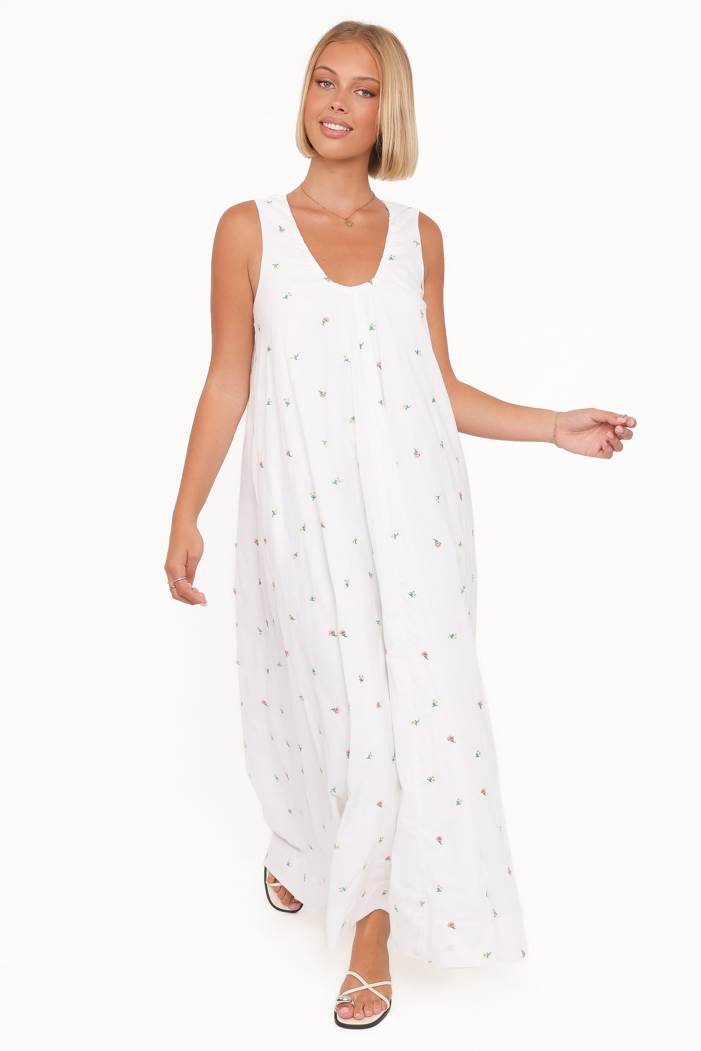 Woman wearing a white dress with a subtle pattern on a white background