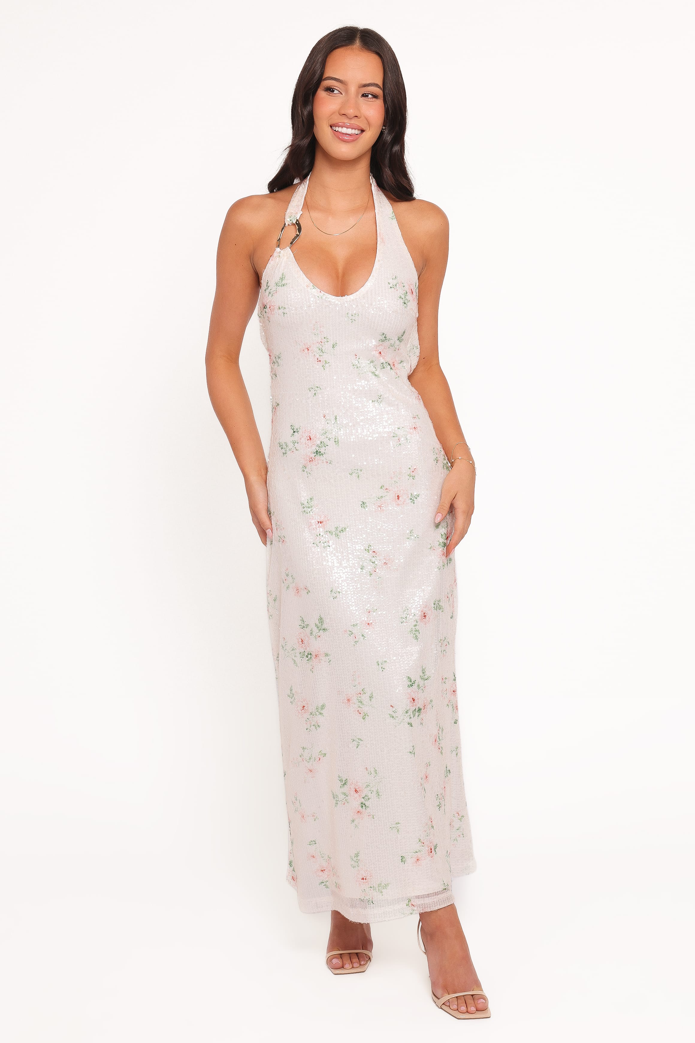 Woman wearing a floral halter neck dress on a white background