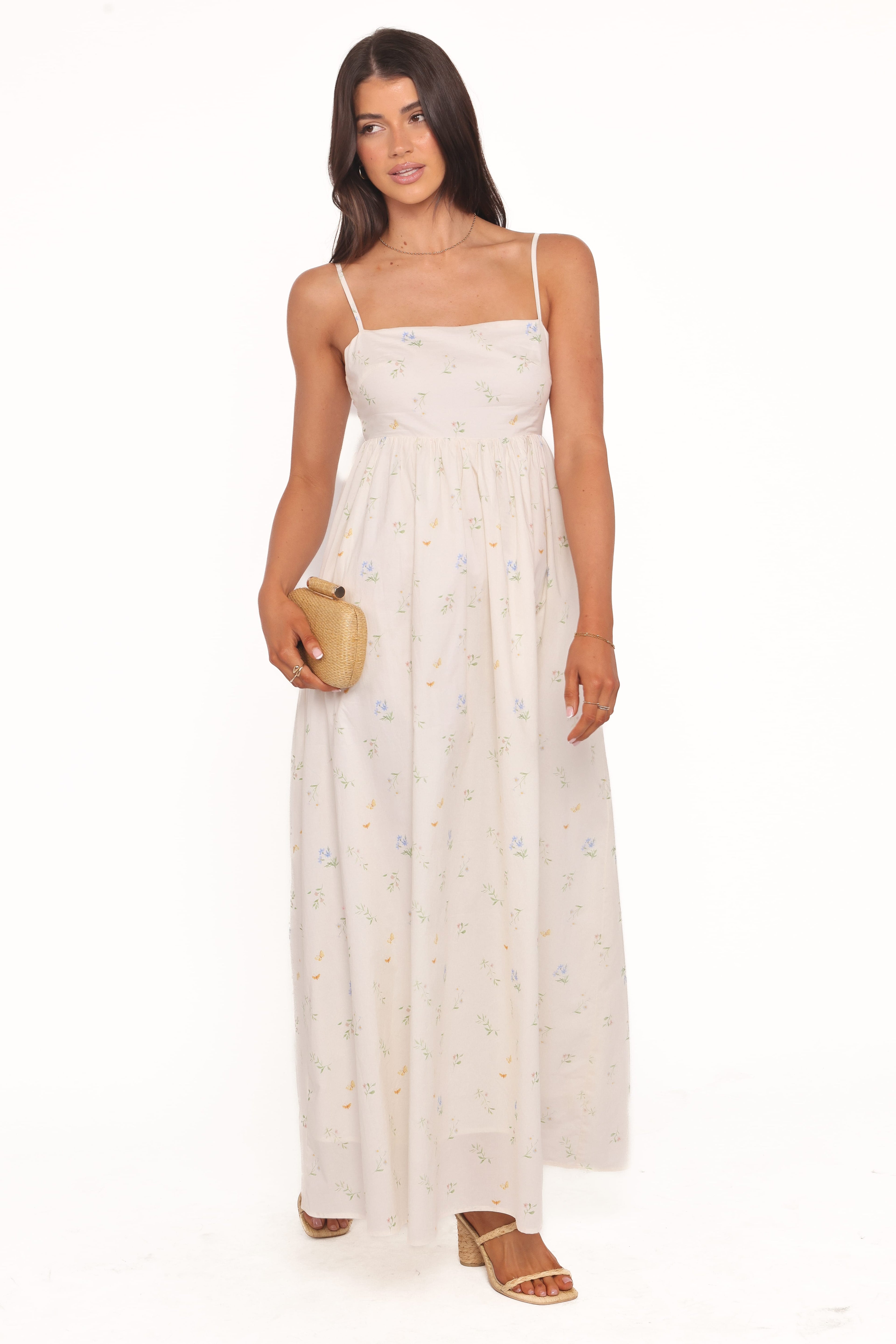 Woman wearing a white dress with thin straps on a white background