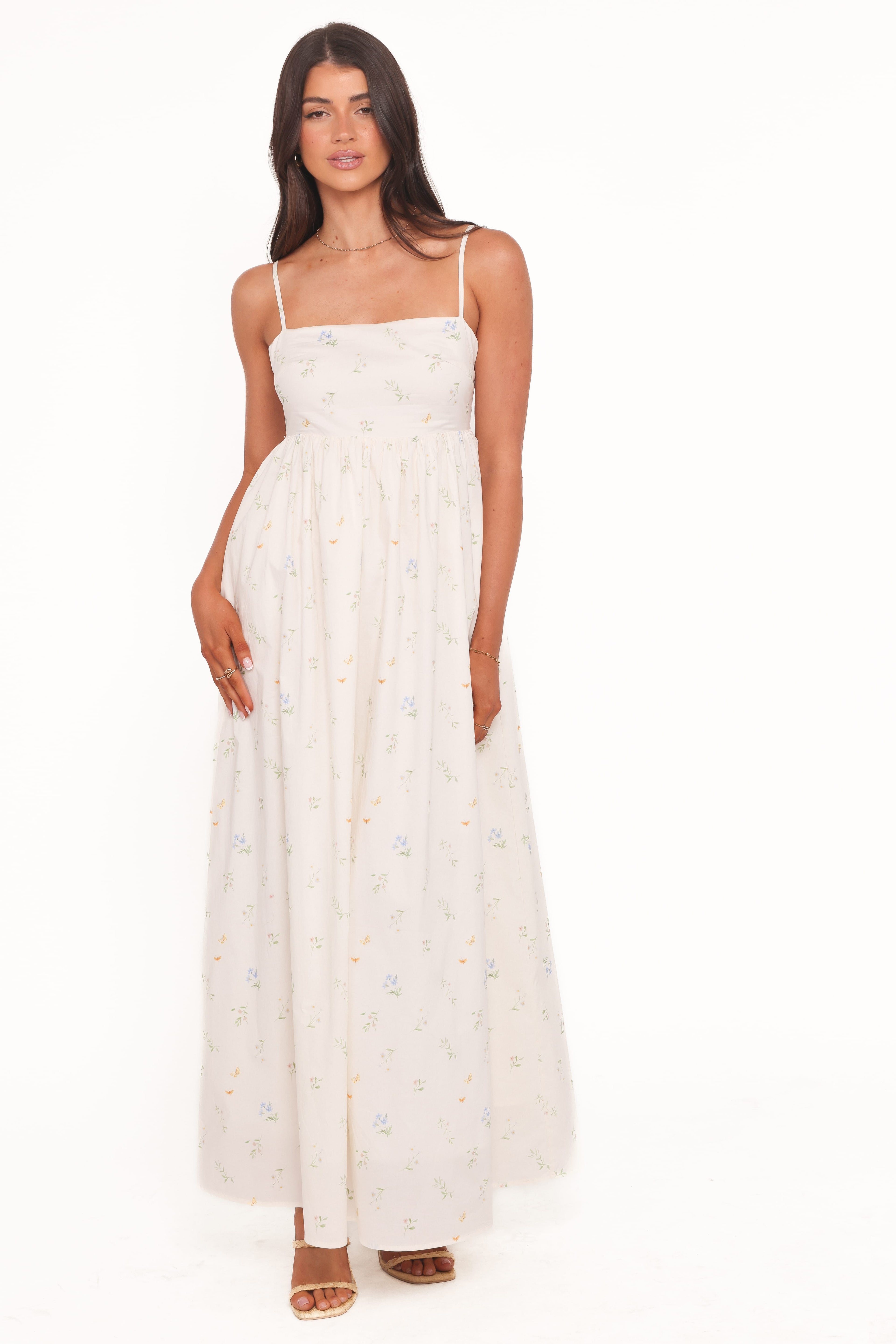 Woman wearing a white dress with thin straps on a white background