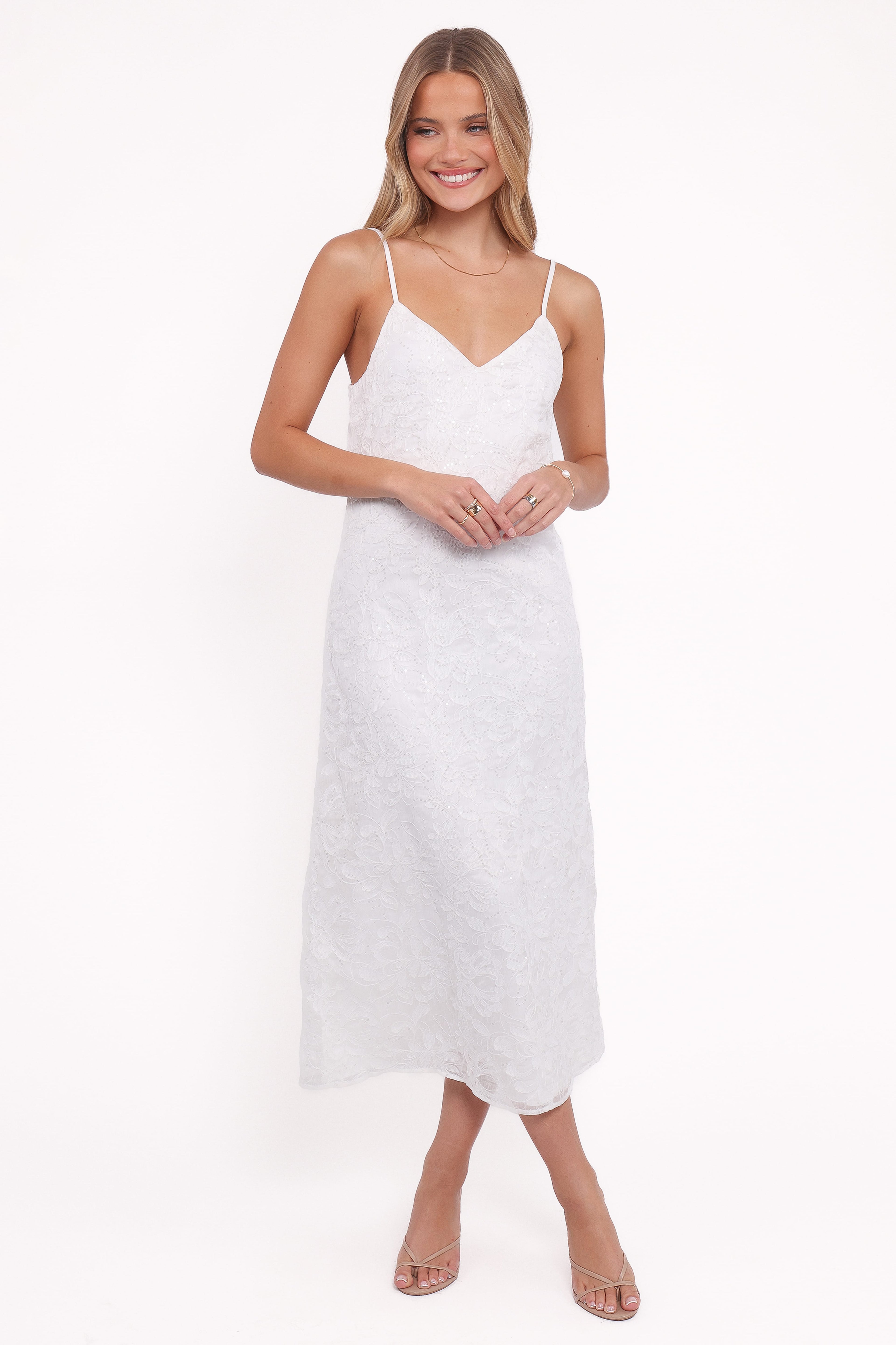 Woman wearing a white slip dress on a white background