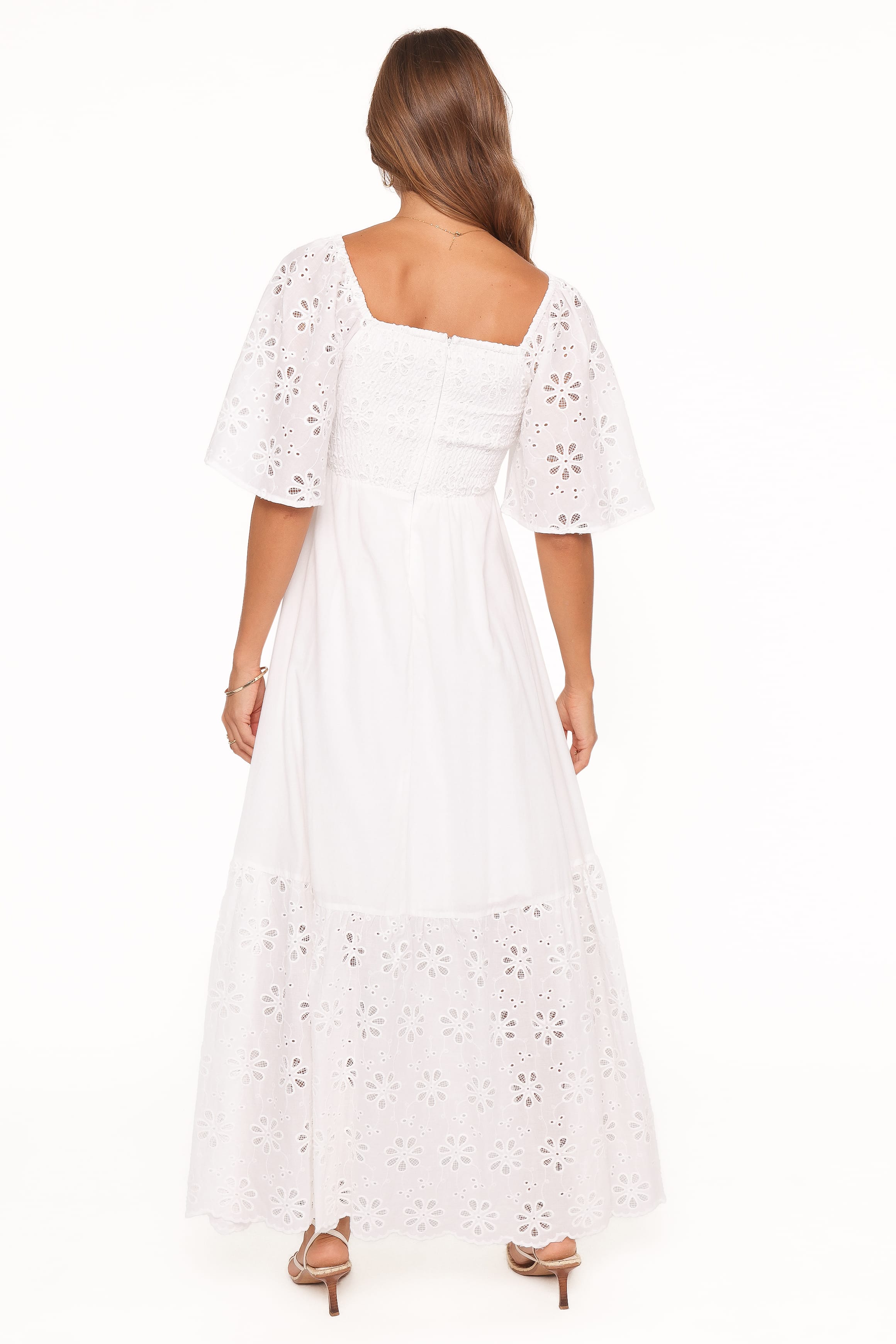 White lace dress worn by a model on a white background
