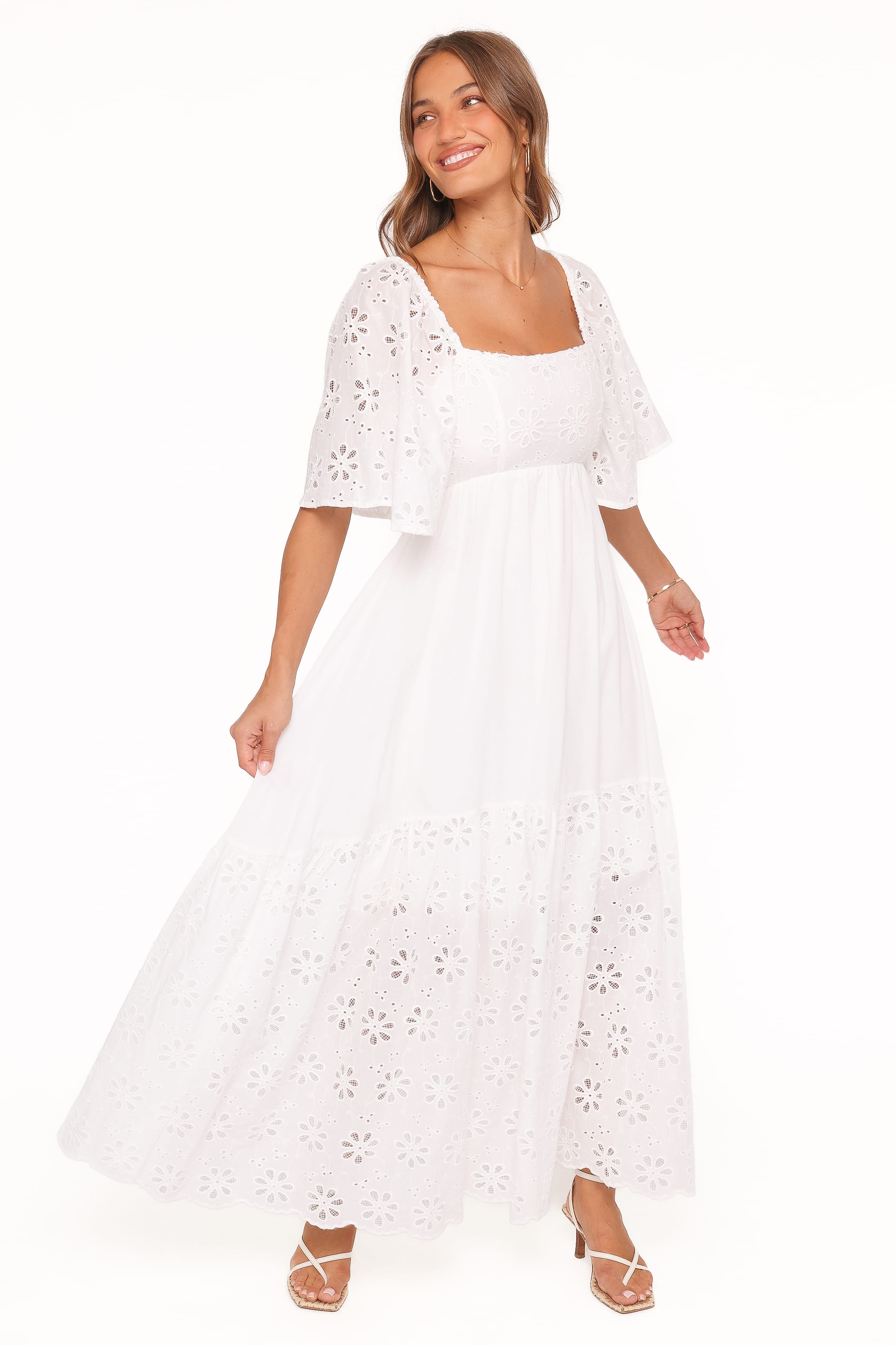 Woman wearing a white lace dress with a white background