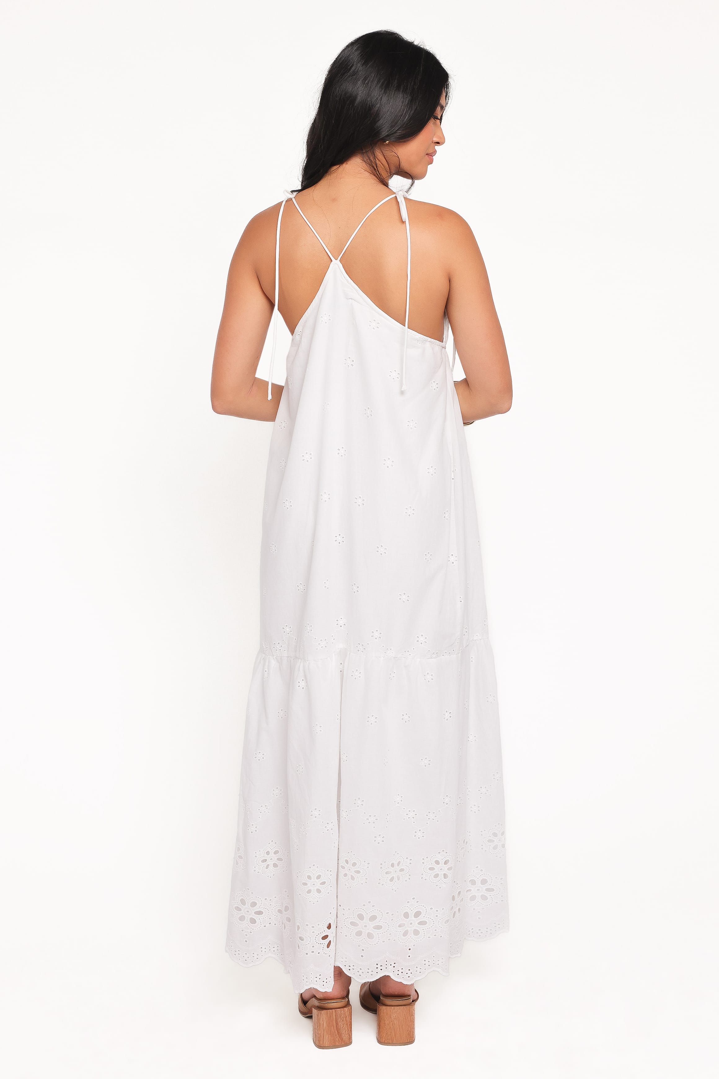 Woman wearing a white dress with cut-out details on a white background